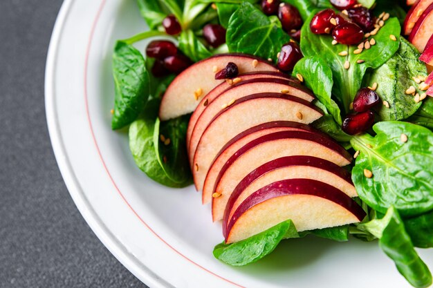 apple salad, green mix lettuce, pomegranate grain healthy meal food snack on the table copy space