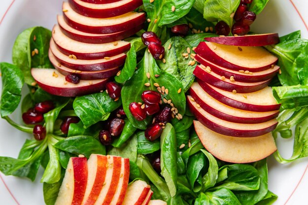 apple salad, green mix lettuce, pomegranate grain healthy meal food snack on the table copy space