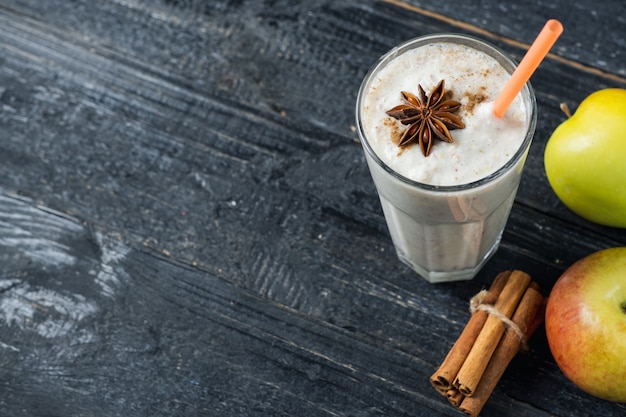 Apple smoothie with cinnamon on wooden table