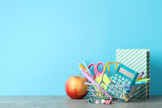 Apple and stationary on grey table. Study concept