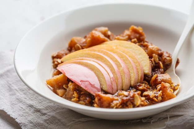 Apple sugar oat crisp in white plate.