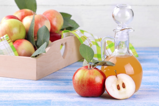 木製の背景に新鮮な熟したリンゴとリンゴ酢
