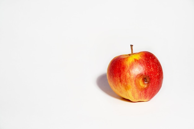 Apple on a white background Ugly foodThe spoiled side of the apple began to rot Food without GMOs Copy space