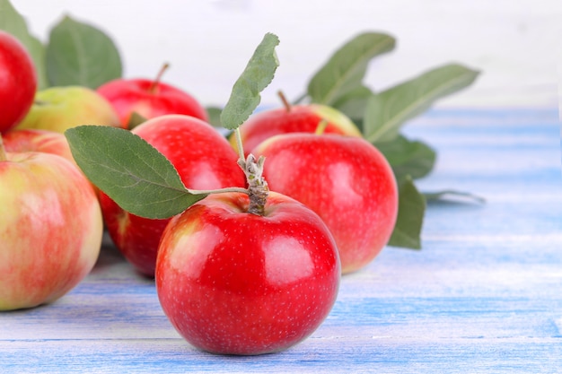 apple with green leaves close-up on a wooden background