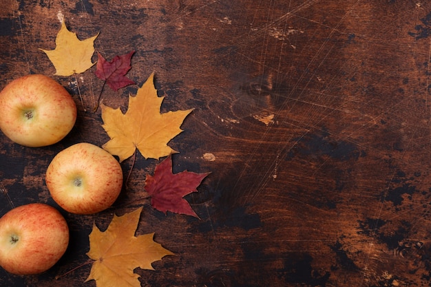 Apple e foglie di acero rosse gialle vecchio fondo di legno di lerciume torna al concetto di scuola tema scolastico di stagione disposizione piana, vista dall'alto, spazio di copia