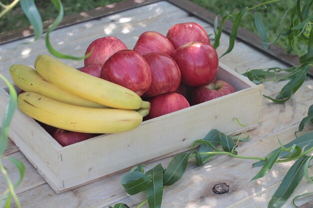 Apples and bananas in a box on a table