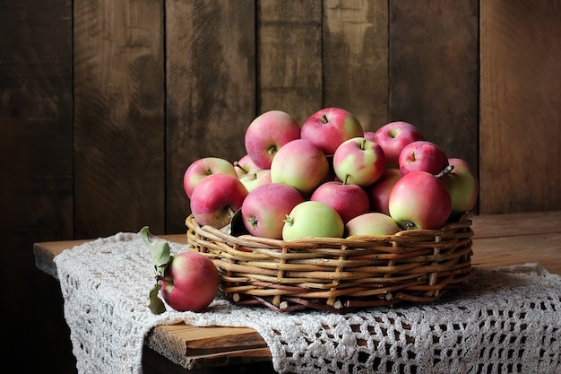 Apples in basket on a wooden table. 