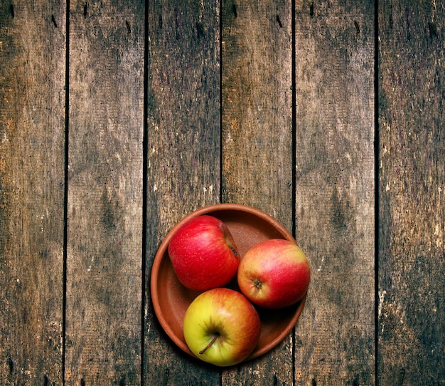 Apples in bowl on wooden table