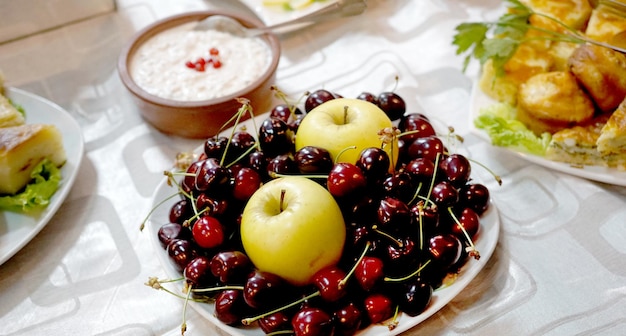 Apples and cherries in a plate