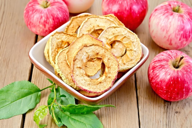 Apples fresh and dried in bowl on board with sheet