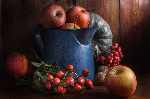 apples in a garden jug on a dark wooden background in a rustic style