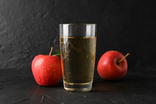 Photo apples and glass with juice on black table, copy space