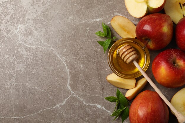 Apples and honey on gray, top view