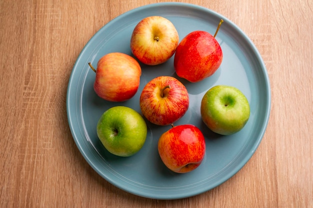 apples on a light blue plate on a wooden table