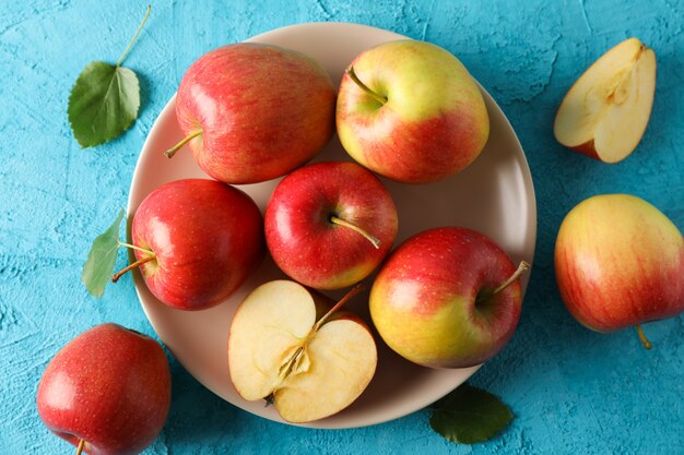 Apples and plate on blue table