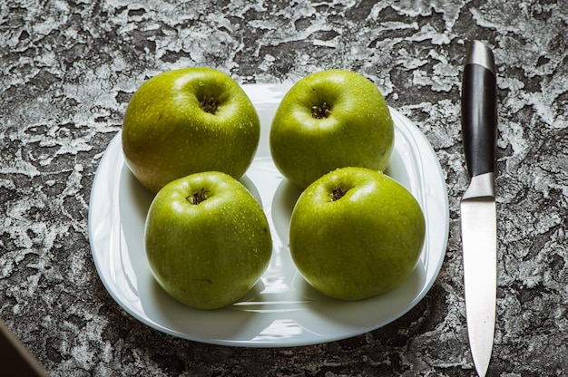 Apples in a plate on a gray background