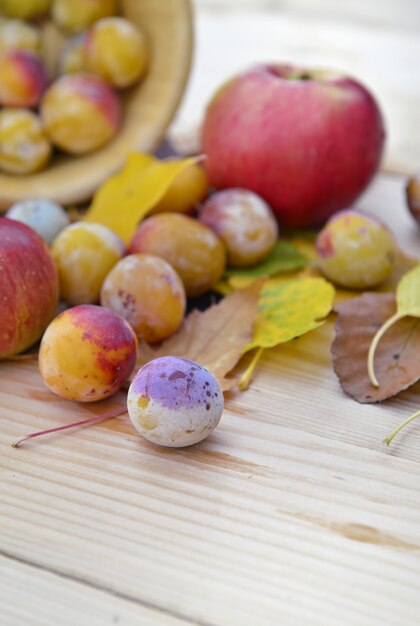 Apples and plums on table