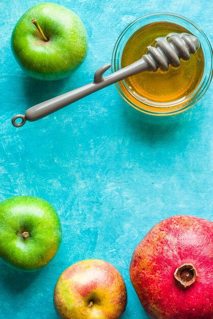청록색 테이블에 사과 석류와 꿀