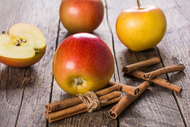 Apples with cinnamon on wooden table