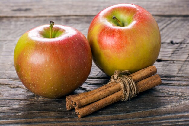 Apples with cinnamon on wooden table