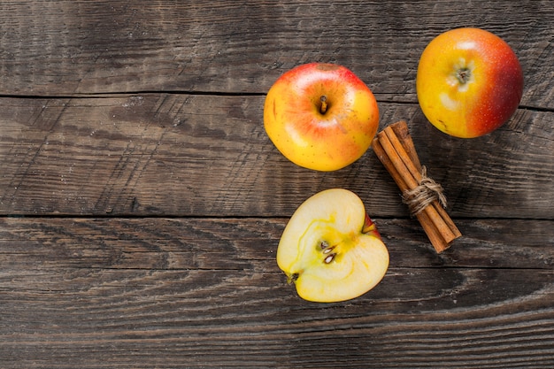 Apples with cinnamon on wooden table