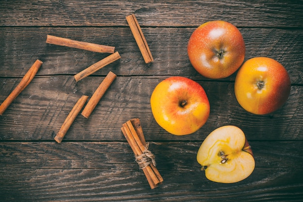 Apples with cinnamon on wooden table