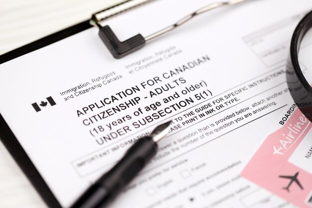 Photo application for canadian citizenship for adults on a tablet lies on office table with pen and