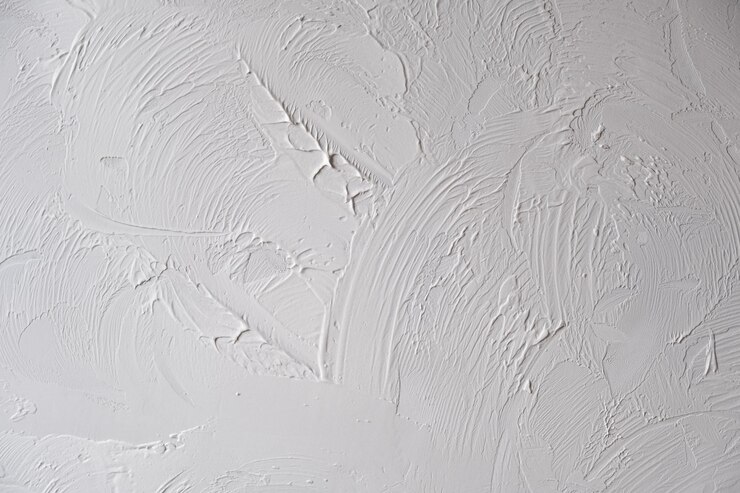 Applying decorative putty white abstract texture of surface covered with putty