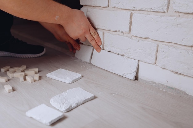 Applying decorative white plaster bricks for an aesthetic interior Making repairs in the apartment