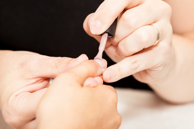 Applicazione di smalto sulle mani di una donna