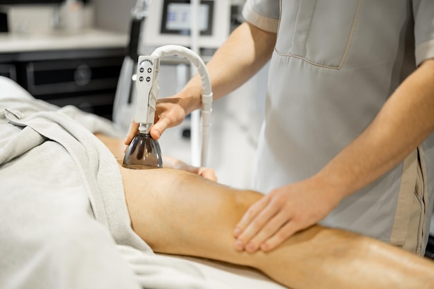 Applying vacuum roller massage on leg