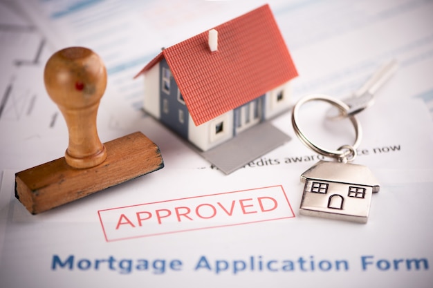 An approved Mortgage loan application form with house key and rubber stamp close up