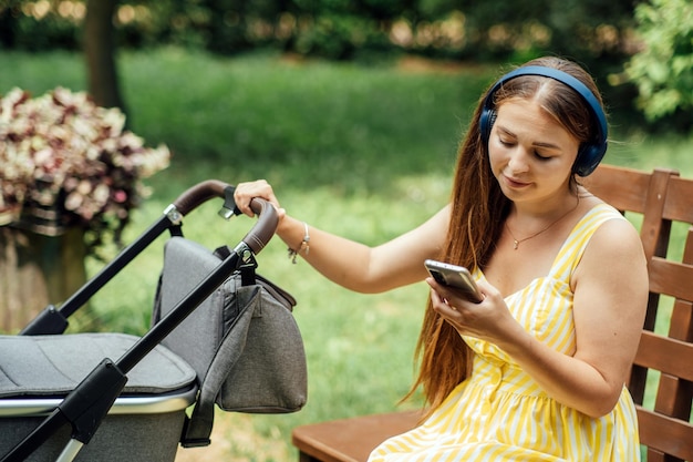 Apps voor moeder jonge moeder met pasgeboren baby in kinderwagen met mobiele app moeder met smartphone