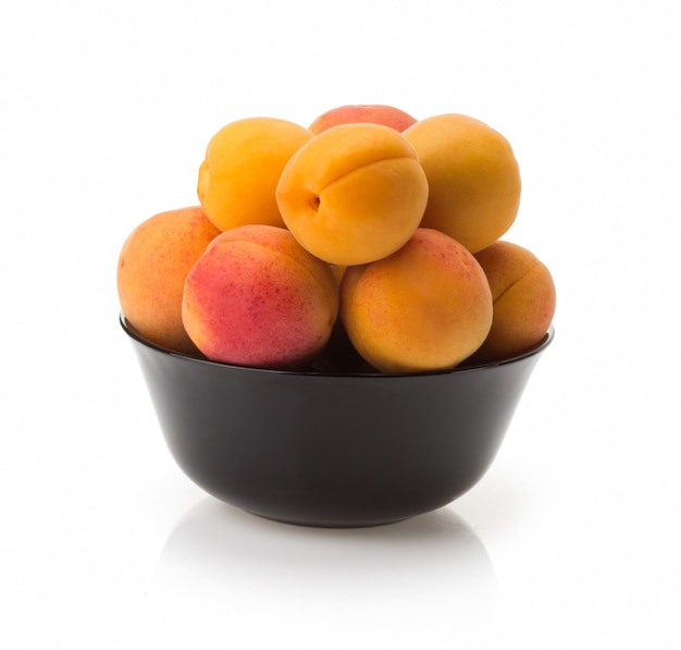 Apricot in bowl isolated on white background