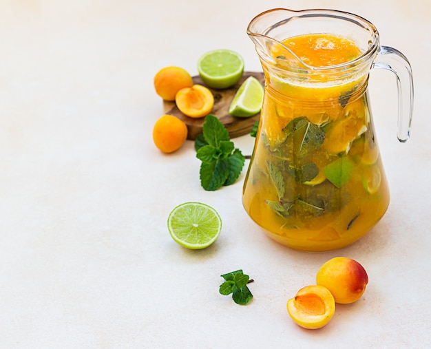 Apricot cocktail or ice tea with fresh mint, lime and apricots. Summer refreshing cold drink.