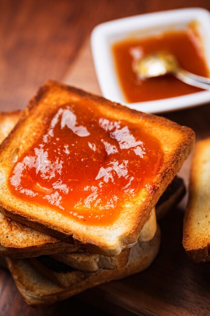 Photo apricot jam on toast bread slice