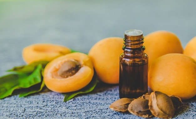 Apricot kernel oil in a small bottle. Selective focus. Nature.