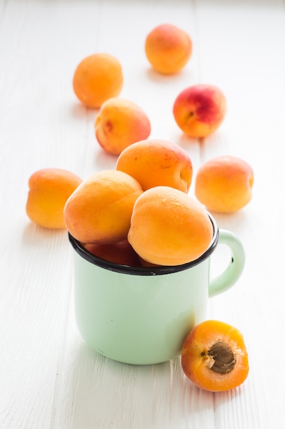 Apricot in tea cup on a white wooden table