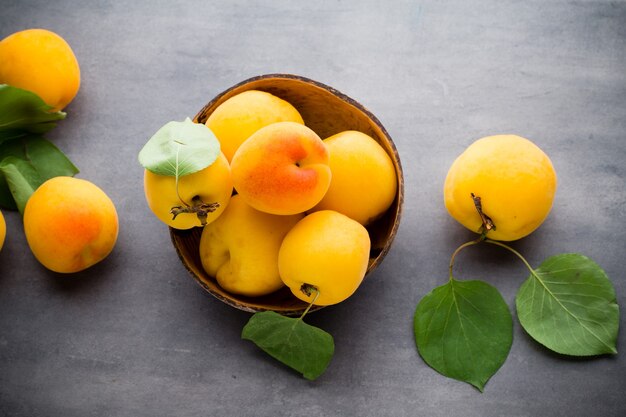 Apricot with leaves on wooden background