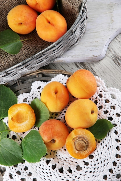 Apricots in basket on napkin on wooden table