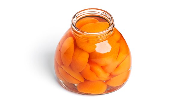 Apricots canned in glass jar. Sweet apricots in syrup isolated on white.