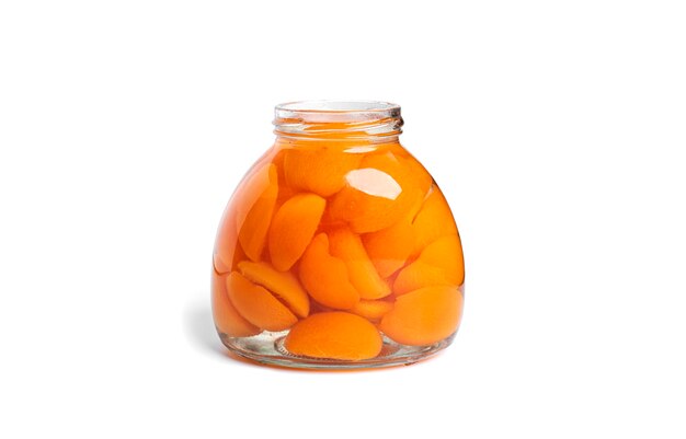 Apricots canned in glass jar. Sweet apricots in syrup isolated on white.