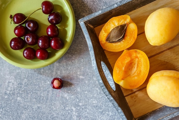 Apricots and cherries on a gray marble table