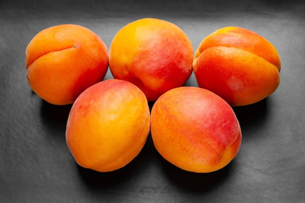 Apricots on a dark background Fresh juicy apricots stacked on a dark clay plate
