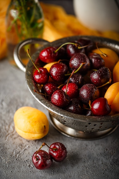 Apricots, sweets cherries in colander