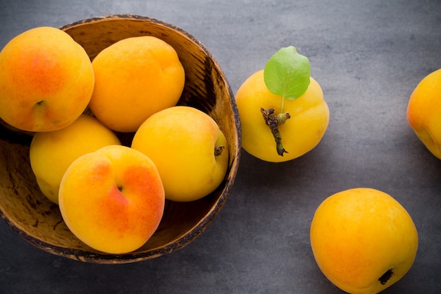 Apricots with leaves on the old wooden table