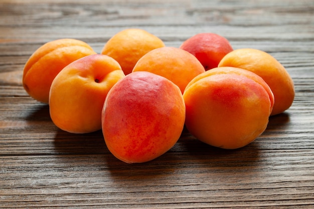 Apricots on wooden background Pile of fresh juicy apricots piled on a wooden table