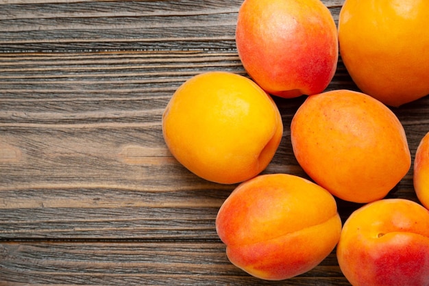 Apricots on wooden background Top view fresh juicy apricots piled on a wooden table