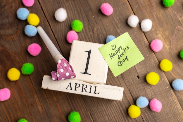 April 1st Image of april 1 wooden calendar with colorful decor on wooden background April Fool's Day