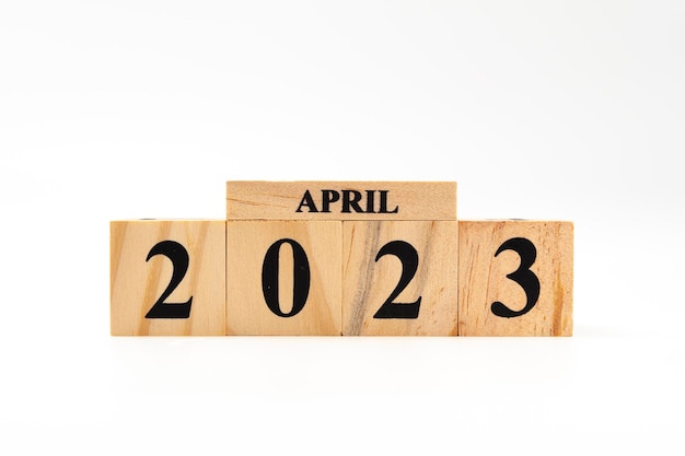 April 2023 geschreven op houten blokken geïsoleerd op een witte achtergrond met kopieerruimte